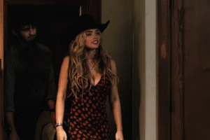 Oreana's cherry print dress + black cowboy hat on Dutton Ranch
